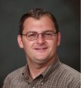 man with brown hair and glasses