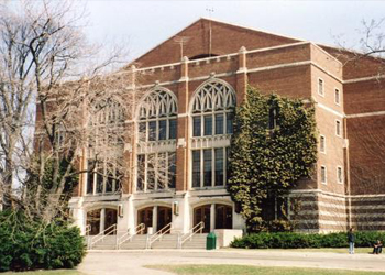 Exterior of building with brick, stone, and large ornate windows