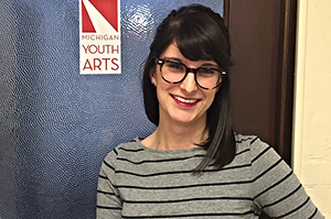 Brittany Nicol in front of a Michigan Youth Arts Sign