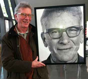 man holding photograph portrait of himself