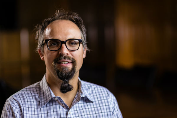 portrait of man with blue eyes, brown hair, and glasses