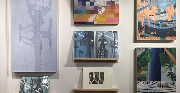 close-up of art pieces hung up on a wall at an exhibition