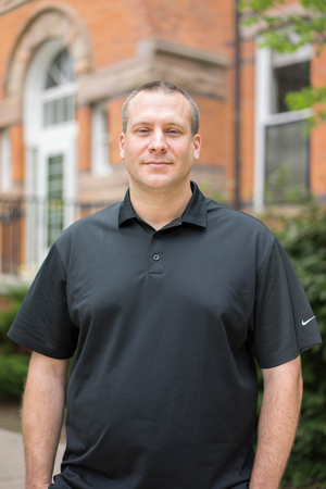 portrait of a man wearing a black polo