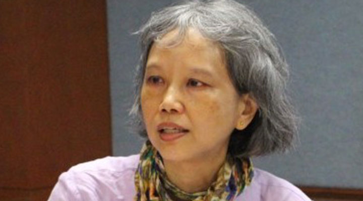 a women wearing a scarf and a purple shirt with short hair