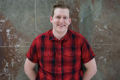a man wearing a red and black checkered button down