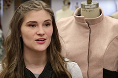 a girl with long brown hair with a pink jacket behind her