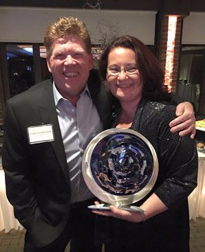 man and woman pose with award
