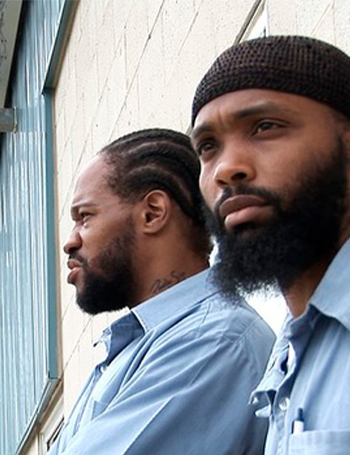 Photo from the movie Cooler Bandits, two men stare off to the left