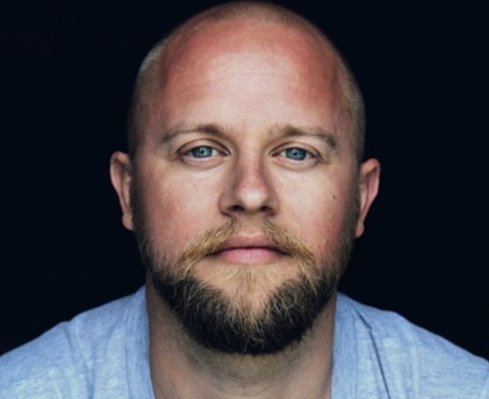 man wearing a blue t shirt staring straight at the camera