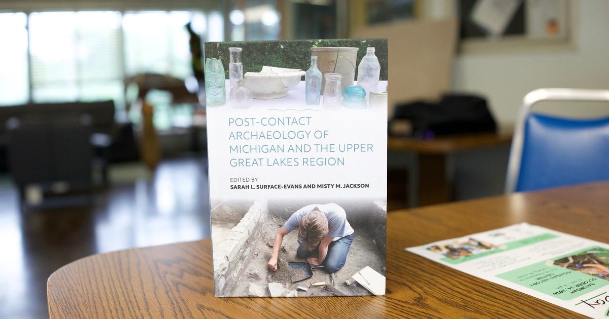 Book cover of Post-Contact Archaeology of Michigan and the Upper Great Lakes Region displayed on a table.